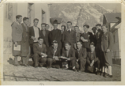 1944. Il Coro di Collina diretto dal m.o Alberto Agostinis (al centro nella foto, accanto a don Massimo Felice) ritratto nel cortile dellas cuola. A d., la casa Bianchi/Mòdie (203)